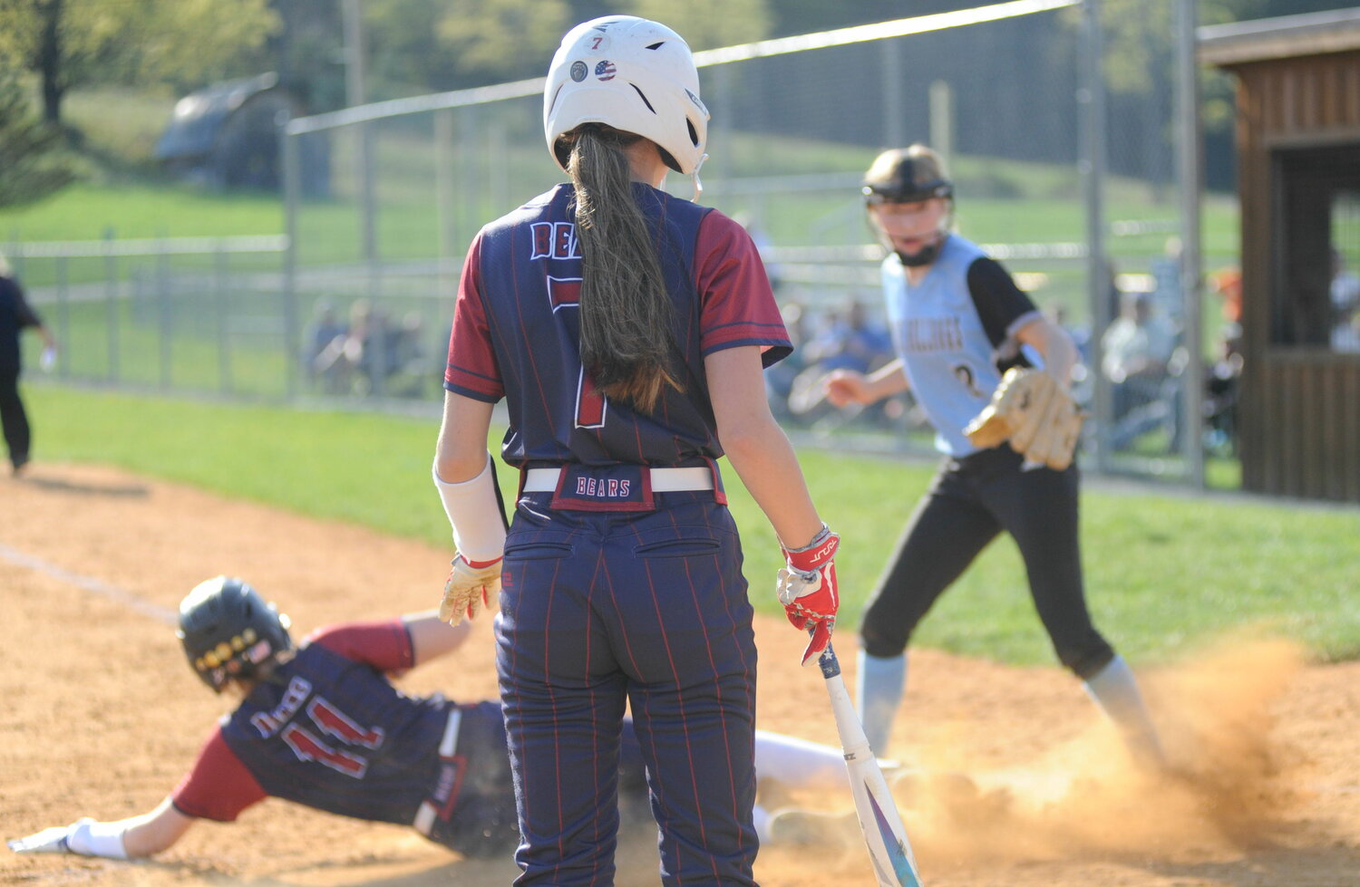 Waiting in the wings. Tri-Valley’s Kaytlyn Ingrassia waits her turn at bat while her teammate Kaitlyn Stungis slides home against Lady Bulldogs pitcher Liz Reeves.